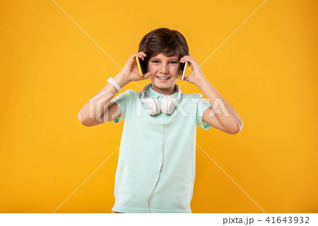 Inspired schoolboy holding two phones 41643932