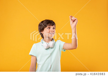 Cheerful preteen holding a tiny pin Cheerful preteen holding a tiny pin 41643983