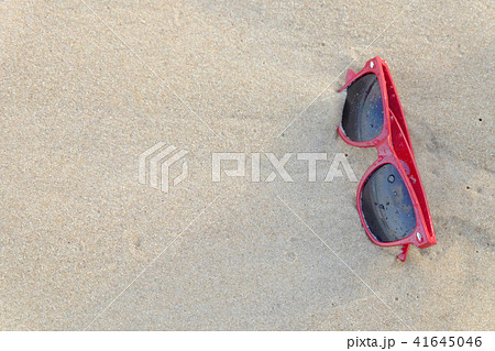A red sun glasses at the beach, on the sand. A red sun glasses at the beach, on the sand. 41645046