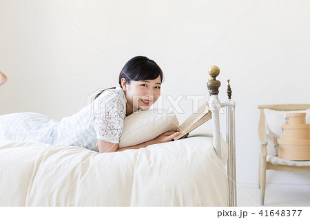 ベッドに寝そべって本を読む若い女性 ベッドに寝そべって本を読む若い女性 41648377