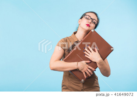 Portrait of excited young woman holding a suitcase isolated over blue background, Travel, holidays 41649072