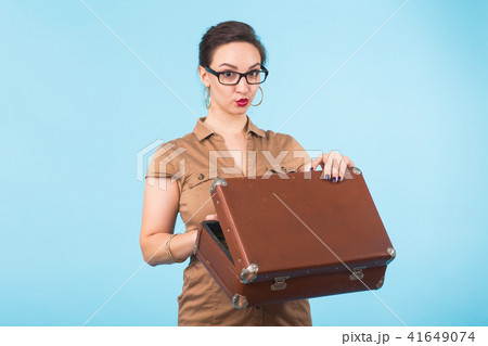 Portrait of excited young woman holding a suitcase isolated over blue background, Travel, holidays 41649074