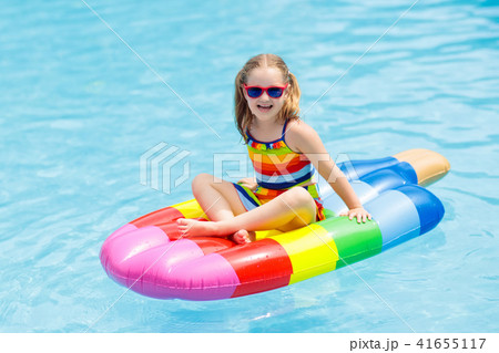 Child on inflatable float in swimming pool. Child on inflatable float in swimming pool. 41655117