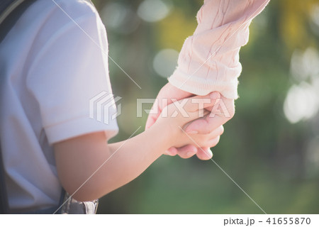 Mother holding hand of little son with backpack Mother holding hand of little son with backpack 41655870