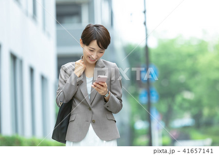 携帯電話を持ったスーツの女性　オフィスレディ　新緑　OL　ビジネス　スーツ　ポートレート　リクルート 41657141