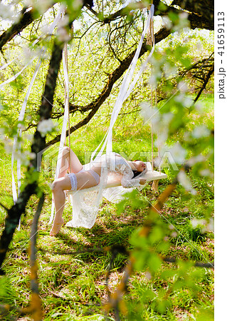 Young sexy bride laying on a white swing in seductive pose 41659113
