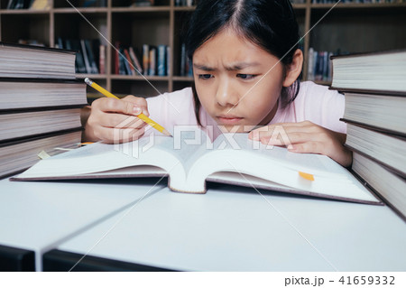 Girl reading and writing and do homework in library Girl reading and writing and do homework in library 41659332
