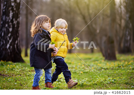 Cute little children playing together in sunny spring park 41662015