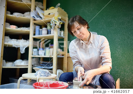 woman making clay object. The sculptor during work 41662057