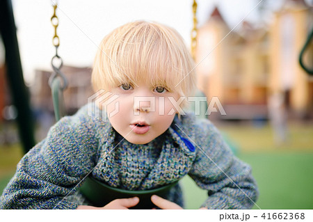 Cute little boy having fun on outdoor playground Cute little boy having fun on outdoor playground 41662368