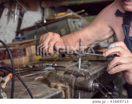 Older man in harnees at home workshop. Close up 41669713