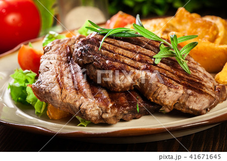 Grilled fillet mignon served with baked potatoes 41671645