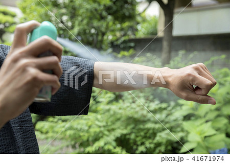 虫よけスプレーをする甚平姿の男性手元 41671974