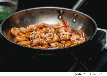 Shrimp on frying pan. Thermal processing of food. Electric cooker in a restaurant 41673240