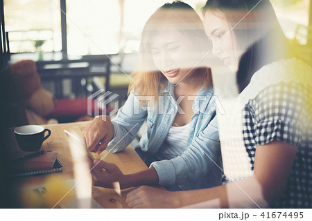 two young beautiful women chatting in a coffee two young beautiful women chatting in a coffee 41674495