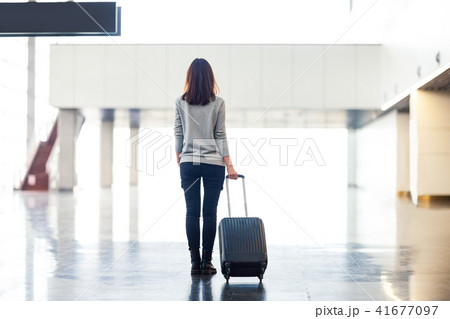 woman with suitcase in airport terminal 41677097