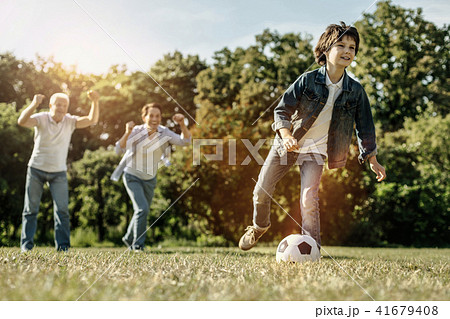 Boy playing the ball and his family supporting him 41679408