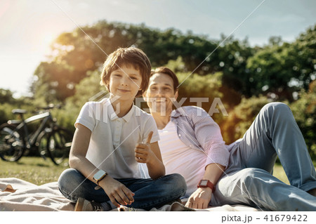 Boy showing thumb up and sitting with his dad 41679422