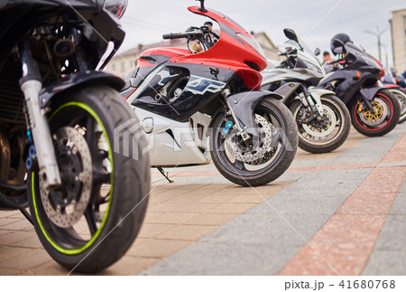 Motorcycles in a row, on the city square 41680768