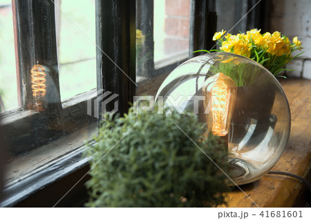 Yellow flowers in a pot and an electric lamp on an Yellow flowers in a pot and an electric lamp on an 41681601