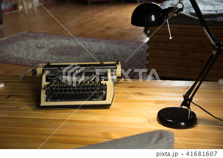 An old typewriter and a lamp on a wooden lacquered An old typewriter and a lamp on a wooden lacquered 41681607