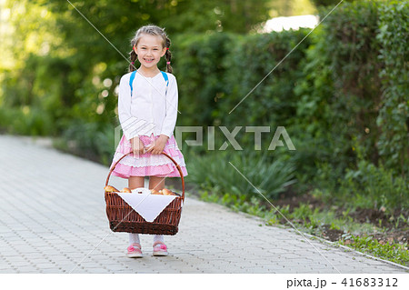A child with a basket of bread is on the road. A child with a basket of bread is on the road. 41683312