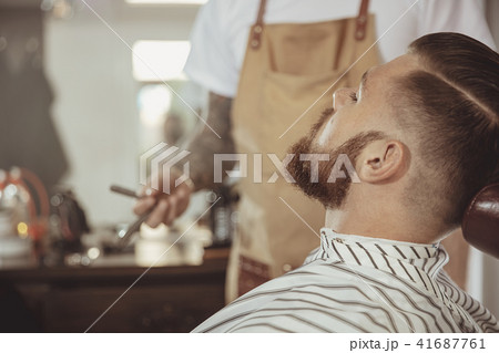 Man with a beard waits for a shave with a razor 41687761