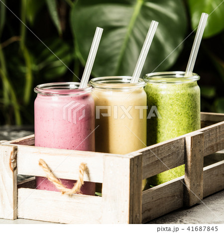 Fresh smoothies on tropical background Fresh smoothies on tropical background 41687845