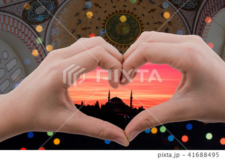 mosque view seen behind a heart shaped hand mosque view seen behind a heart shaped hand 41688495