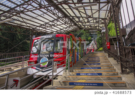 御岳山ケーブルカー 滝本駅に停車する赤い車両と階段状のホームの写真素材