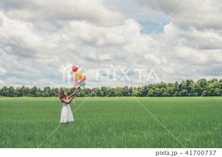Happy young beautiful woman holding balloons 41700737