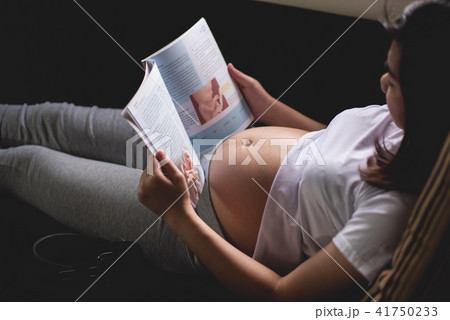 Pregnant woman reading a book on the sofa Pregnant woman reading a book on the sofa 41750233