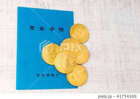 仮想通貨 ビットコインと年金手帳のイメージの写真素材
