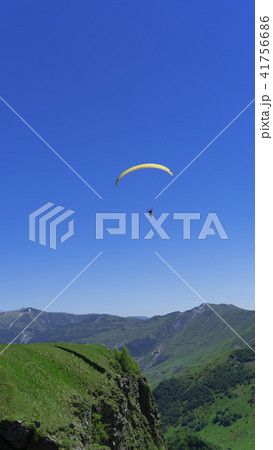 A paraglider with people flies over the mountain  41756686