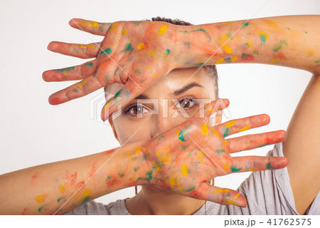 Close-up portrait girl covers face palms in paint Close-up portrait girl covers face palms in paint 41762575