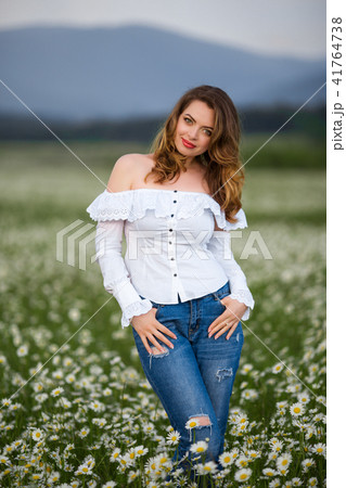 Beautiful girl on the camomile field is wearing casual clothes, spring time Beautiful girl on the camomile field is wearing casual clothes, spring time 41764738