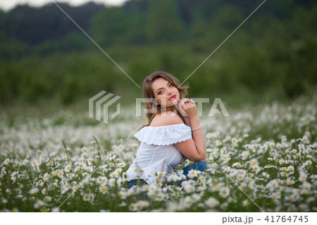 Beautiful happy woman on the camomile field is wearing white dress, spring time Beautiful happy woman on the camomile field is wearing white dress, spring time 41764745