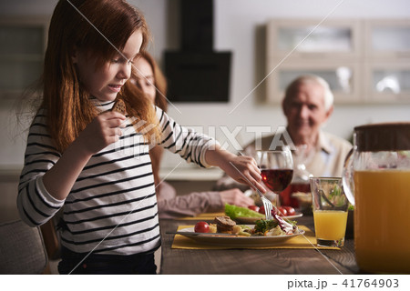 Small girl eating healthy meal at table 41764903