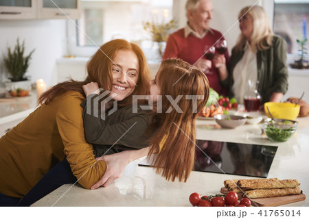 Smiling woman playing with daughter in kitchen Smiling woman playing with daughter in kitchen 41765014