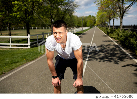 Fit tired man is having rest during race in countryside Fit tired man is having rest during race in countryside 41765080