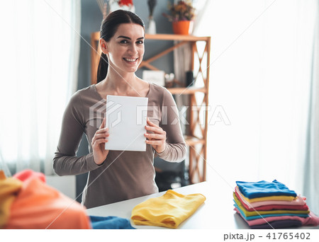 Delighted housewife displaying detergent at home Delighted housewife displaying detergent at home 41765402