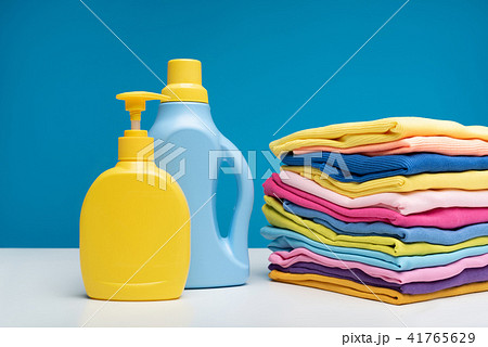 Heap of clean clothes folded near detergents 41765629