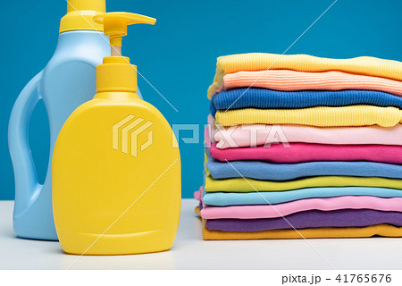 Washing detergents and pile of clean garments on table Washing detergents and pile of clean garments on table 41765676