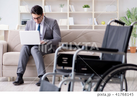 Dsabled businessman on wheelchair working home 41768145