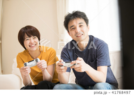 テレビゲームで遊ぶ日本人カップルの写真素材