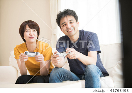 テレビゲームで遊ぶ日本人カップルの写真素材