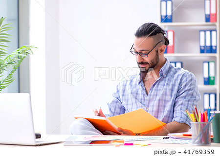 Young designer working in his studio on new project Young designer working in his studio on new project 41769359