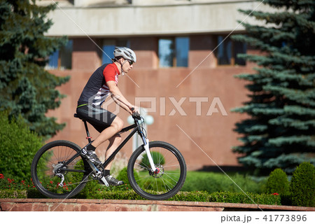 Male cyclist training on street edging 41773896