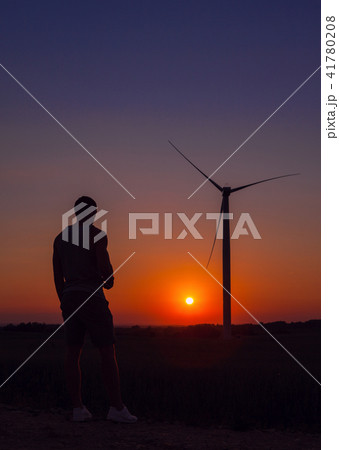 Man looking windmills at sunset. 41780208