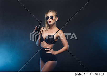 Blonde woman holding bottle of wine. Beautiful female model. Hot lady in black lingerie. Fashion 41781161